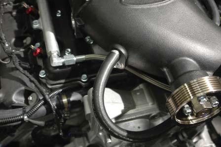 153. Route the hose forward, under the supercharger inlet and