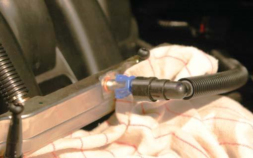 Press on the blue tabs of the fuel line locking clip and then pull the line free.