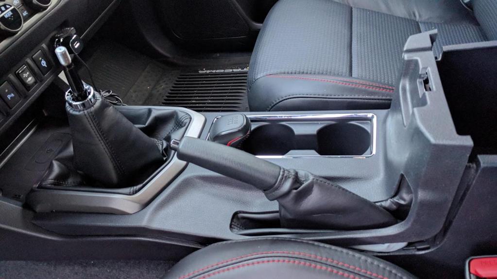 Continue to lift the center console cover over the gearshift lever and handbrake handle.