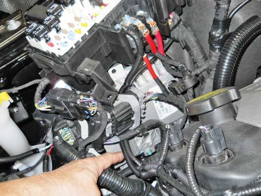 Retain the engine harness to the front cover using the zip tie