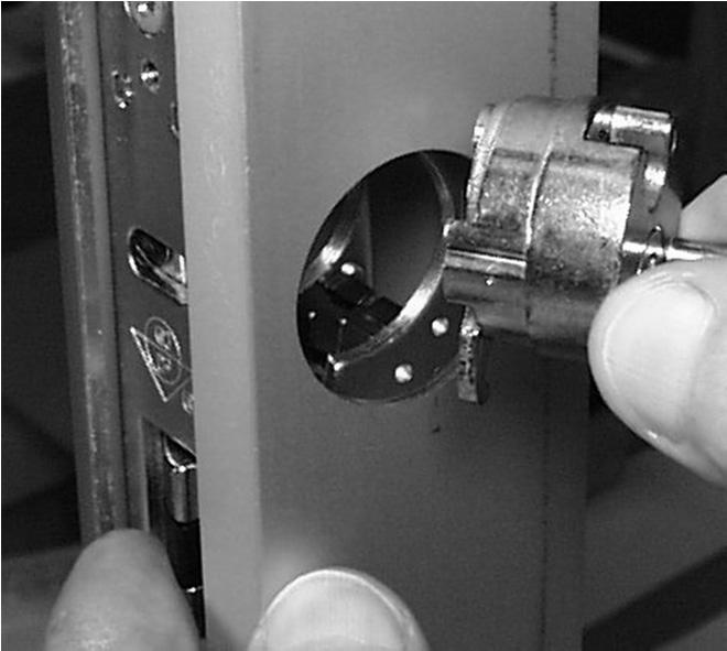 While holding in the latch, carefully insert the interface cylinder assembly into the cylinder hole.