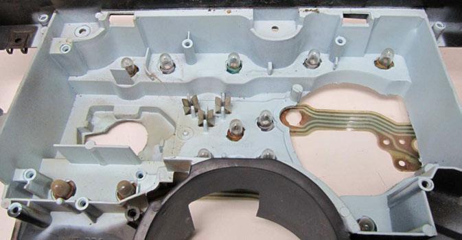 Using a die grinder, Dremel tool, or cut-off wheel, carefully trim the plastic bosses as shown.