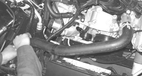 Undo the clip that retains the upper radiator hose to the fan shroud and remove the