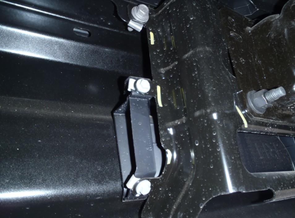 Remove bolts from both sides of the vehicle. Open a panel to locate a hidden screw.