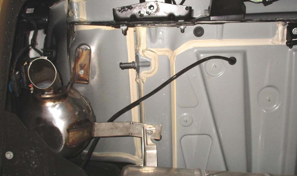 - Remove the rubber grommet shown on the vehicle underbody. Route the wire for the sound module out of the vehicle.