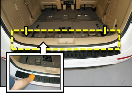 Then, use a non-marring trim removal tool to remove the trunk scuff guard trim, as shown.