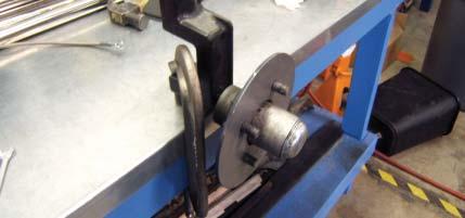 In order to weld Caliper Mount Brackets (H) to spindles and ensure proper wheel clearance, the wheel, spacer, rotor, and