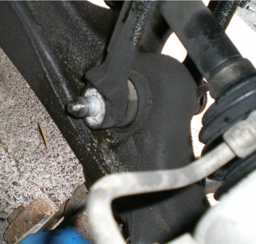 Loosen the nut that secures the lower clevis bolt. Unscrew it almost off, then hit the bolt firmly with the large hammer until you get the bolt out.