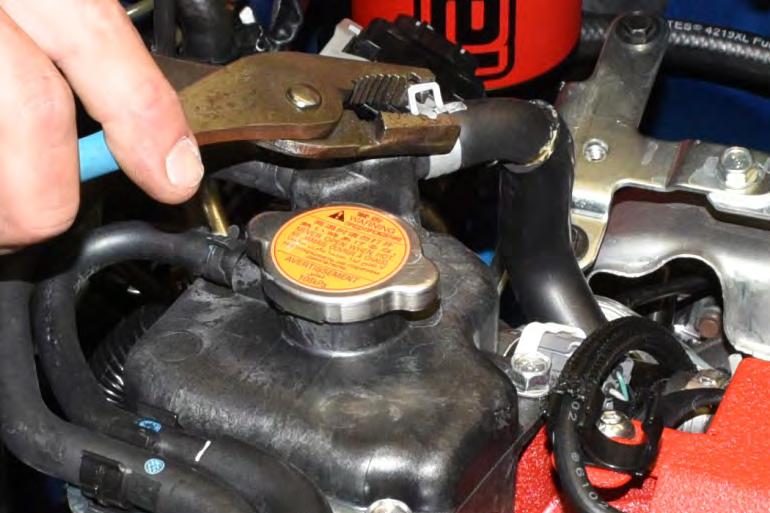 43. Using pliers remove the OEM upper coolant expansion tank hose clamp.