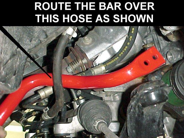 Route the bar over the hose as shown.