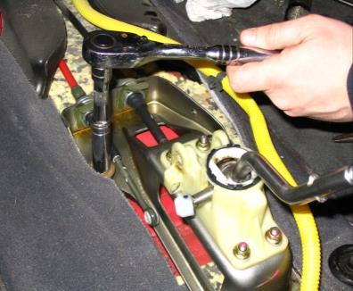 Remove the arm and spring from the assembly while taking note of the orientation of the spring for re-installation.