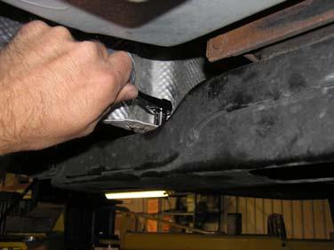 heat shield. Re-install the two (2) bolts holding the heat shield to the transmission cross-member.