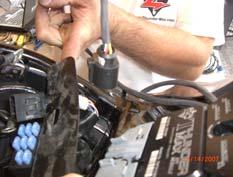 Lift the battery up from the oil tank and remove the battery cables (negative first). Remove the battery.