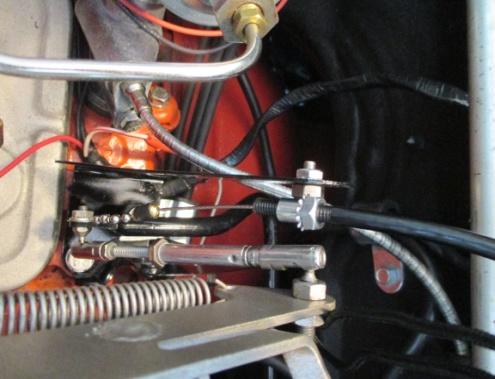 This location allows cruise cable routing across the top of the firewall and behind the engine bay wiring harness.