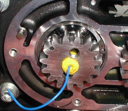 6. Insert the supplied foam plug into the hole in the center of the main shaft gear. Leave the string hanging out of the plug so it can be removed later. See Figure 15.
