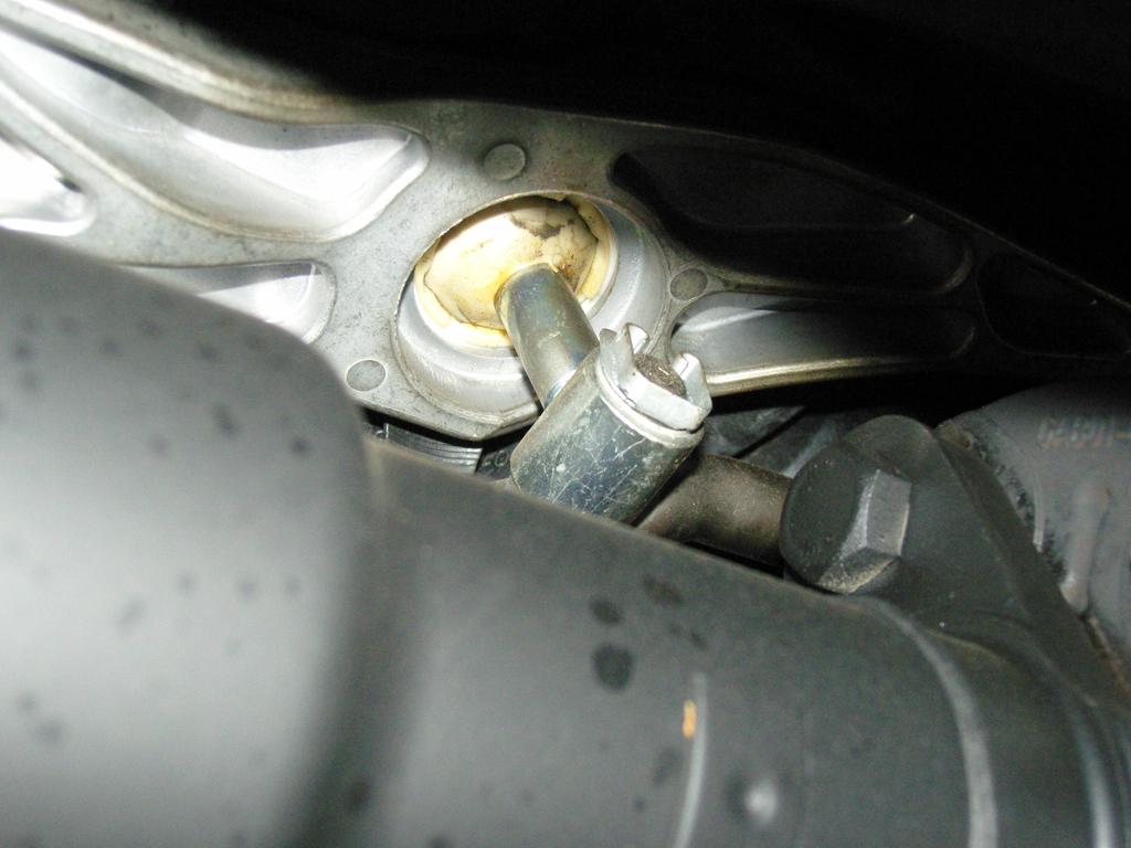 Locate and identify shifter lower pivot. Identify and remove lower pivot clip that connects the linkage arm to the bottom of the shifter lever.