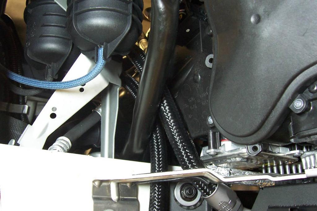 30. Route the oil line as shown in figure 28. Attach the Oil Cooler Assembly to the car as shown previously with the two stock 8mm nuts and the 6mm bolt. Torque nuts to 20Nm (15ft-lbs.