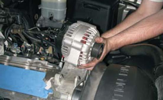 With a 15mm socket wrench remove the two bolts holding the alternator