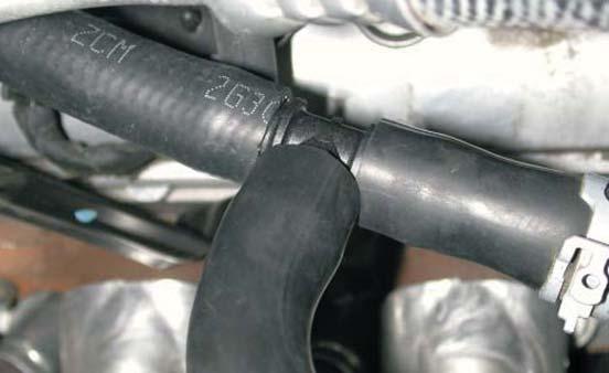 Using the factory hose clamp removed in step 49, install the short end of the