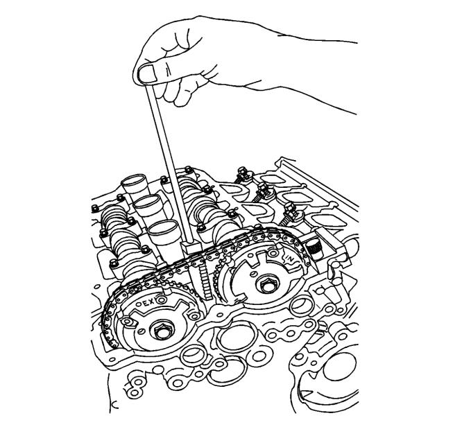 16. Insert the EN49982-2 retainer between the two camshaft position actuators with the teeth on the EN49982-2 retainer facing toward the front cover. 17.