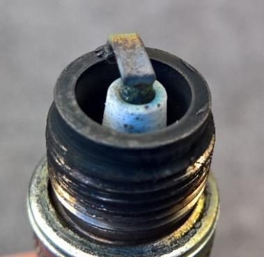 The photograph in figure 4 is of the plug removed from #3 cylinder, and quite plainly shows all the signs of severe overheating.