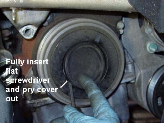 Remove the cover over the vibration damper/belt pulley bolts.