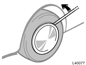 Blocking the wheel Removing wheel ornament (steel wheels only) Loosening wheel nuts 2. Block the wheel diagonally opposite the flat tire to keep the vehicle from rolling when it is jacked up.