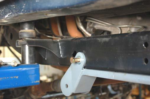 Using the new bracket as a guide, drill using a 17/32 drill bit through the inner and outer frame rail. See Photo 14.