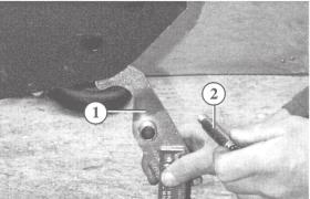 Unscrew the rear attachment screw (11) and remove the nut Pull out the screw and