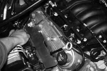 (See Fig 2-a.) C. Gently bend the oil dip stick tube forward and in toward the valve cover. (See Figs 2-a, 2-b.) D. Using three 6mm x 1.