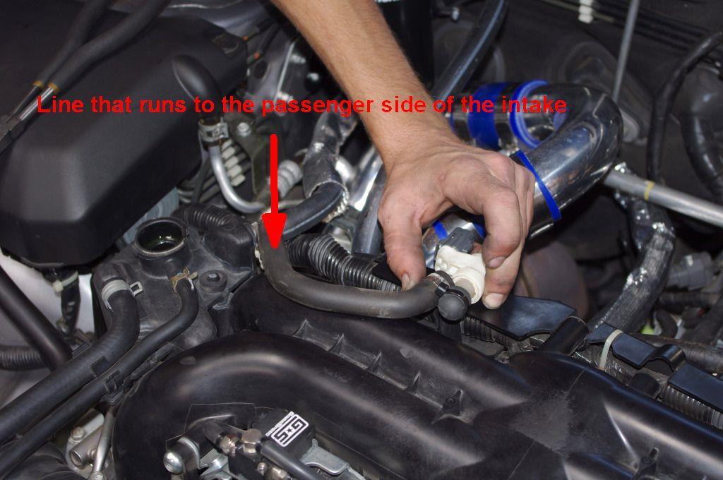 6. Remove the curved rubber hose that runs from the white breather piece to the passenger side of the intake.