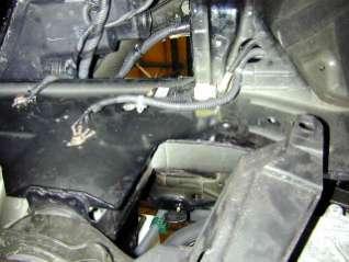 m. Remove the bolt securing the rearward grounding block and unhook the wire clips securing the wires to the chassis. n.