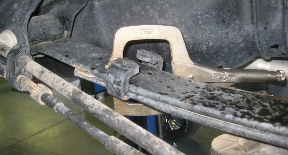Place a vise grip or C-clamp on the outer ends of the rear leaf spring to prevent the leafs from