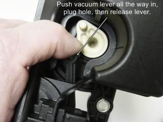 If your unit is badly worn you may need to hold the creme colored bell crank lever in place so that it doesn't try to lift up when prying up the vacuum lever.