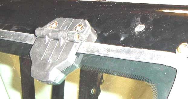 Attach windshield latches to windshield latch receivers on the cowl by squeezing tabs to retract spring loaded pins. See fig. 9.1.1. Lift up on bottom of windshield and close latches.