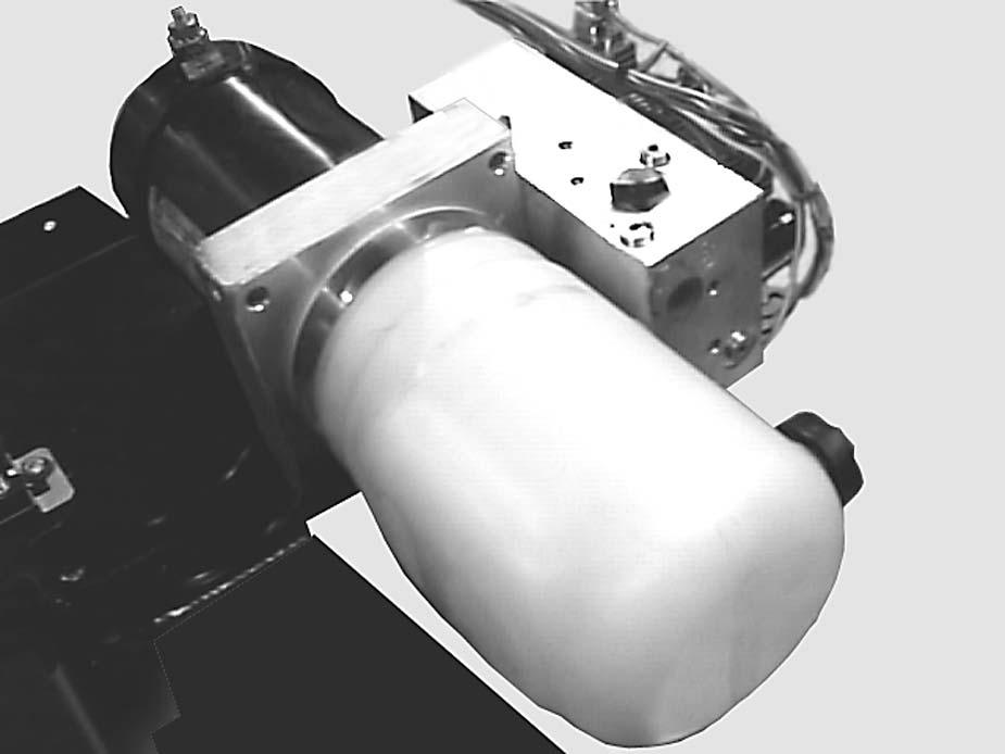 FRONT POWER UNIT FILLER CAP RESERVOIR Figure 2-5 8. Loosen the band clamp, which holds the reservoir on the center section. Pull and twist the reservoir until it separates from the center section.