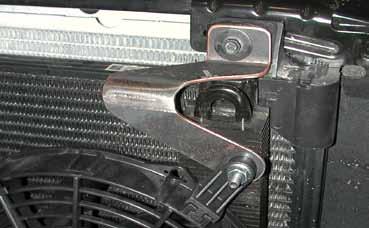 Remove the eight bolts on the upper radiator support bracket and then remove the