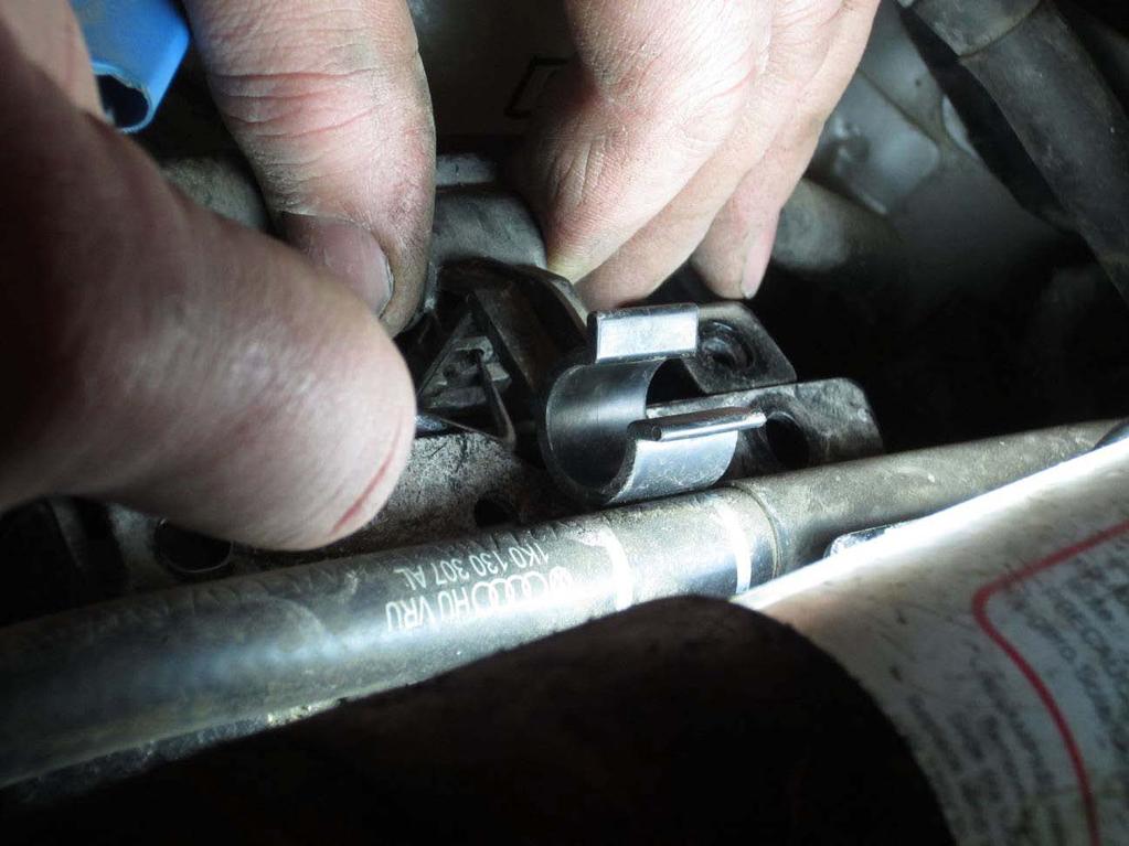 13. Remove fuel line retainer from aux pump bracket.