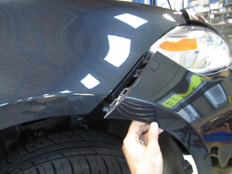 Carefully pull up at top edges of the front bumper