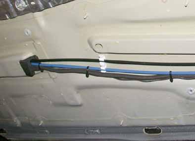 Route wiring harness of metering pump and fuel line in fabric protective hose behind insulation mat to right-hand side of vehicle.