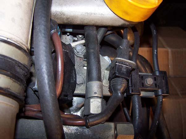 Remove the metal supporting bracket for the diagnostic plug, the cover for the plug, and the spark