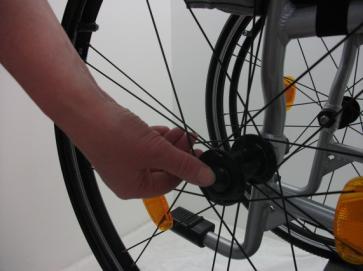 Removing the rear wheel The rear wheels of the wheelchair are removable by using the 'quick-release system: Stand next to the wheelchair; Tilt the wheelchair away from you; Press the black button in