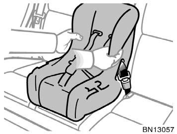 3. While pressing the convertible seat firmly against the seat cushion and seatback, let the shoulder belt retract as far as it will go
