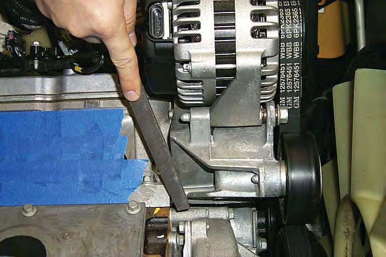 72. Using a fi le or die grinder, remove material from the alternator mounting bracket marked in the