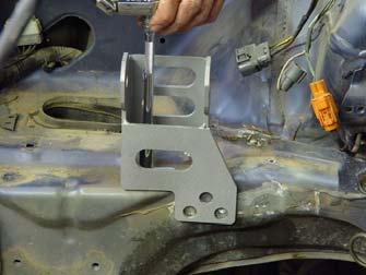 The paint around the markings should be removed before welding the bracket to the frame rail to insure a good weld.