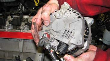 Use a panel puller to remove the harness locating pin from the alternator bracket, remove the bracket, then