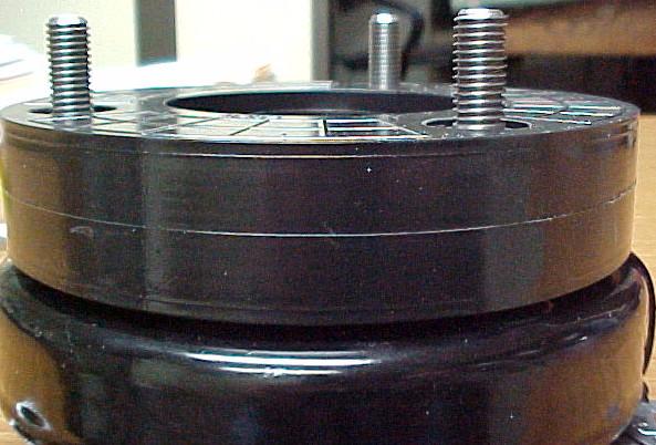 16. INSTALL THE SUPPLIED URETHANE STRUT SPACER OVER THE STRUT EXTENDERS ON TOP OF THE FACTORY STRUT MOUNT. URETHANE STRUT SPACER BEING INSTALLED FACTORY UPPER STRUT MOUNT 17.