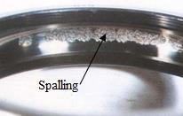 The most common type of surface fatigue damage occurring in bearings is called "spalling" where small chips of the ring race surface start peeling off, as seen in the figure, and that can be detected