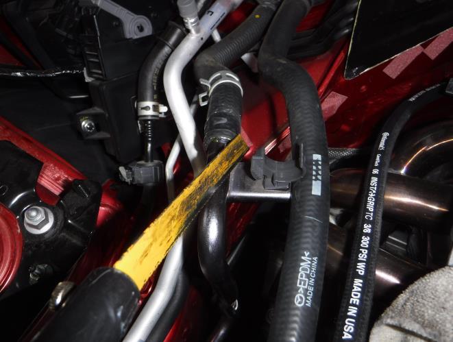 Pull back the spring clips on the two coolant hoses at the fire wall as shown in Photo 3-8. 7.