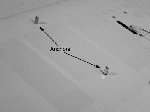 Thread the strut support anchors into the holes in the wing. The anchors have external threads.
